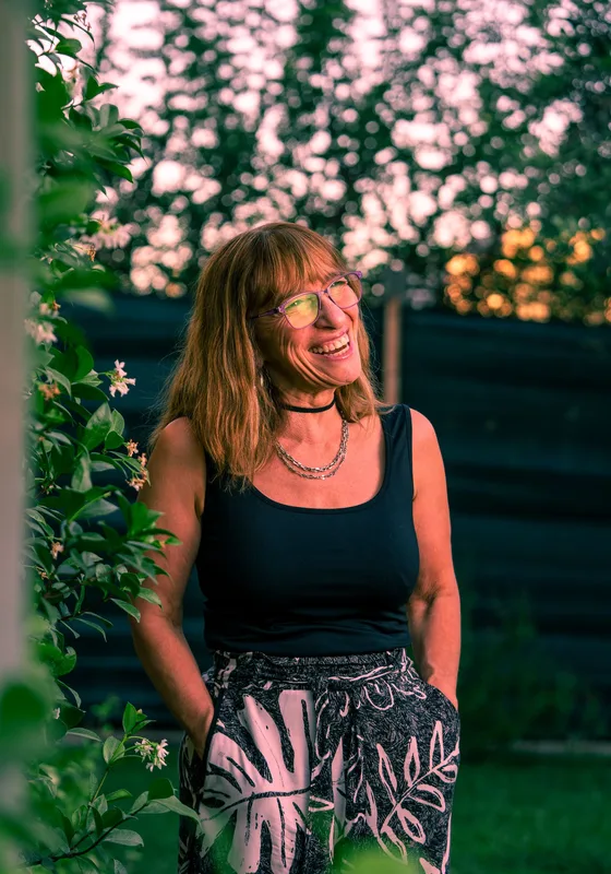 Woman laughing under blossoming vines