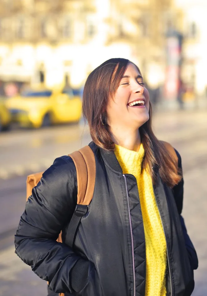 Woman laughing on a city street